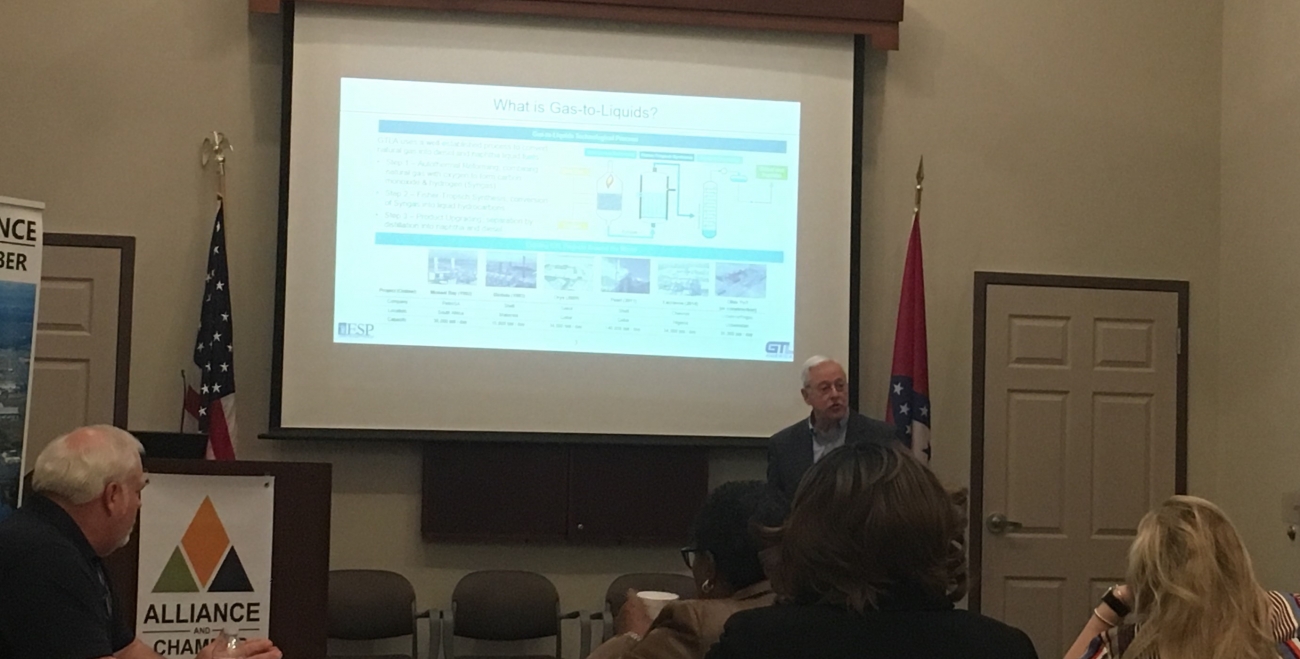 people sitting in a room looking at a projector screen