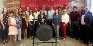 group of people standing behind a gong